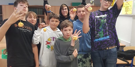 Powiększ grafikę: Chłopcy z 7b pozują do zdjęcia w klasie w rękach trzymając bryloczki z pluszowymi emotikonkami.