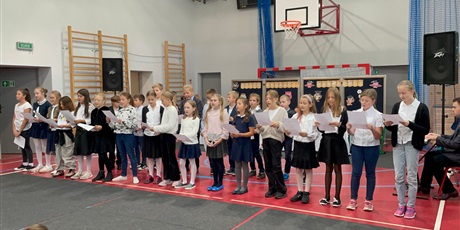 Powiększ grafikę: Uczniowie śpiewają na stojąco piosenkę dla nauczycieli.