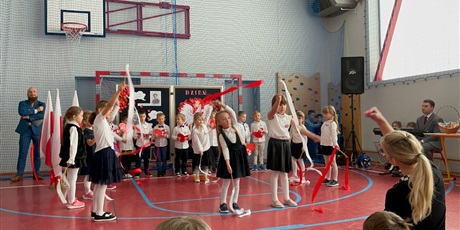 Powiększ grafikę: Dzieci z oddziału przedszkolnego tańczą z biało-czerwonymi szarfami.