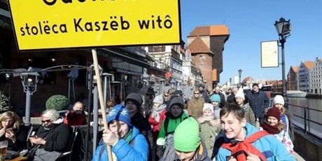 Powiększ grafikę: Kilku uczniów nad Motławą niesie znak z kaszubskim napisem oznaczającym Gdańsk – stolica Kaszub wita. 
