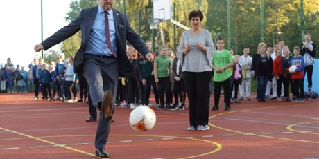 Powiększ grafikę: Dyrektor szkoły oraz Paweł Adamowicz – Prezydent Gdańska na szkolnym boisku – prezydent kopie piłkę. 