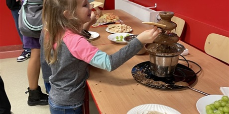 Powiększ grafikę: Dzieci przygotowują i kosztują czekoladowe fondue.