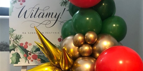 Powiększ grafikę: Plakat informujący o Festynie Świątecznym w otoczeniu balonów w kolorach: czerwonym, zielonym i złotym.