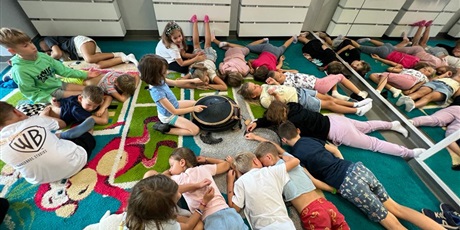 Powiększ grafikę: Dzieci leżą na dywanie i relaksują się przy muzyce.