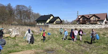 Powiększ grafikę: Grupa dzieci sprząta najbliższą okolicę szkoły - osiedle z zalegających tam śmieci.