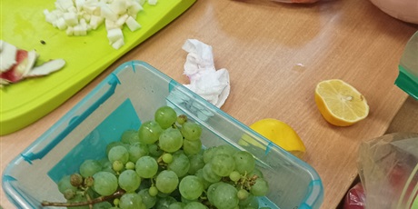 Powiększ grafikę: Winogrona i inne składniki sałatki owocowej na stole.
