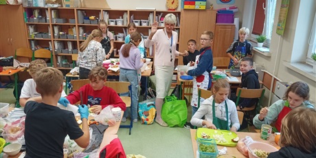 Powiększ grafikę: Klasa z nauczycielką języka polskiego w trakcie przygotowywania sałatek.