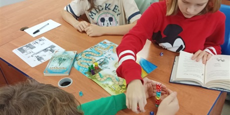Powiększ grafikę: Uczniowie w sali grają w grę planszową.