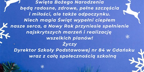 Powiększ grafikę: Świąteczne życzenia na niebieski tle, a dookoła gwiazdki śniegowe i dwa białe renifery, zielone gałązki igliwia.