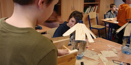 Powiększ grafikę: Uczniowie wykonują karmnik z plastikowej butelki i drewnianych listewek.
