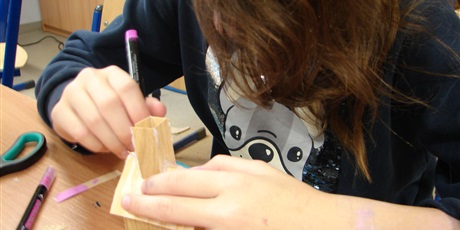 Powiększ grafikę: Uczennica wykonuje drewniany karmnik.