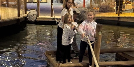 Powiększ grafikę: Trzy dziewczynki stoją na pomoście na wodzie.