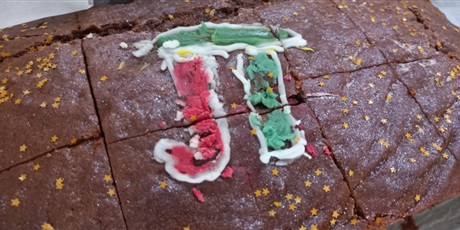 Powiększ grafikę: Ciasto czekoladowe z liczbą Pi namalowana zielono-czeronym lukrem z białą lukrową obwódką.