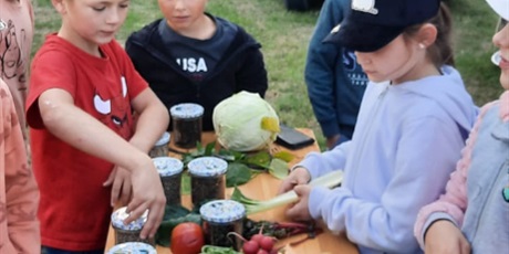 Powiększ grafikę: Grupa uczniów ma zajęcia kulinarne na świeżym powietrzu.